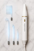 Aura Beauty High-Frequency Facial Wand with four glowing blue electrode attachments displayed on white marble background — luxury skincare device.